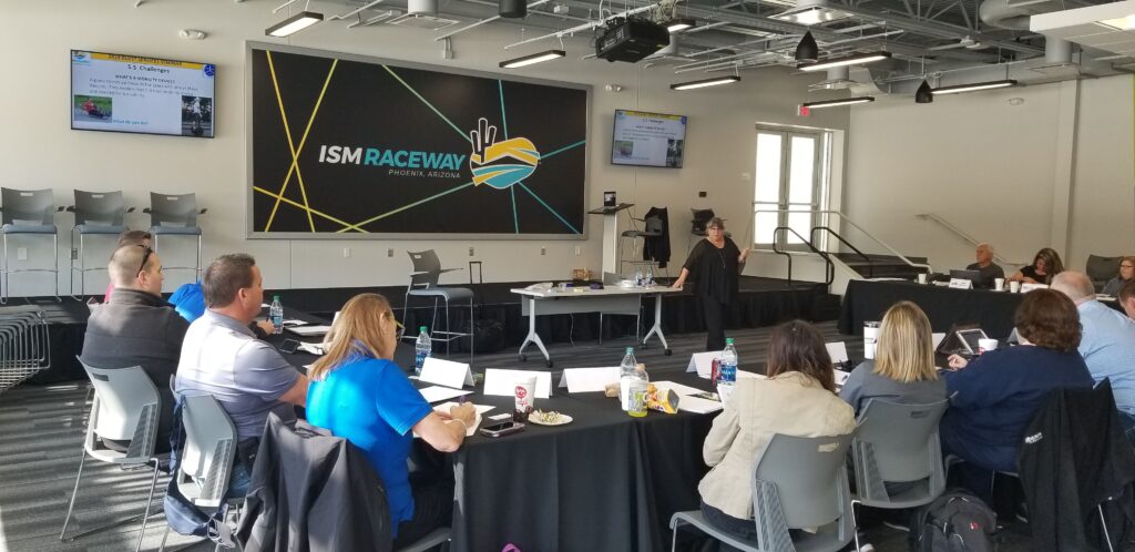 Dr. Nanette Odell speaking to a group of individuals at a guest services seminar at the ISM Raceway.
