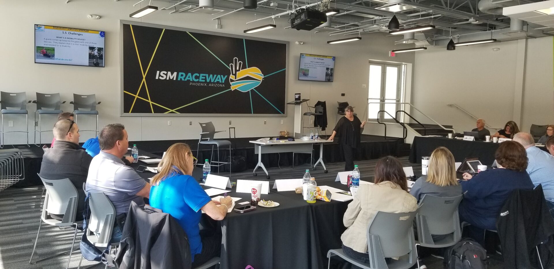 Dr. Nanette Odell speaking in front of a class at a guest services seminar at the ISM Raceway.