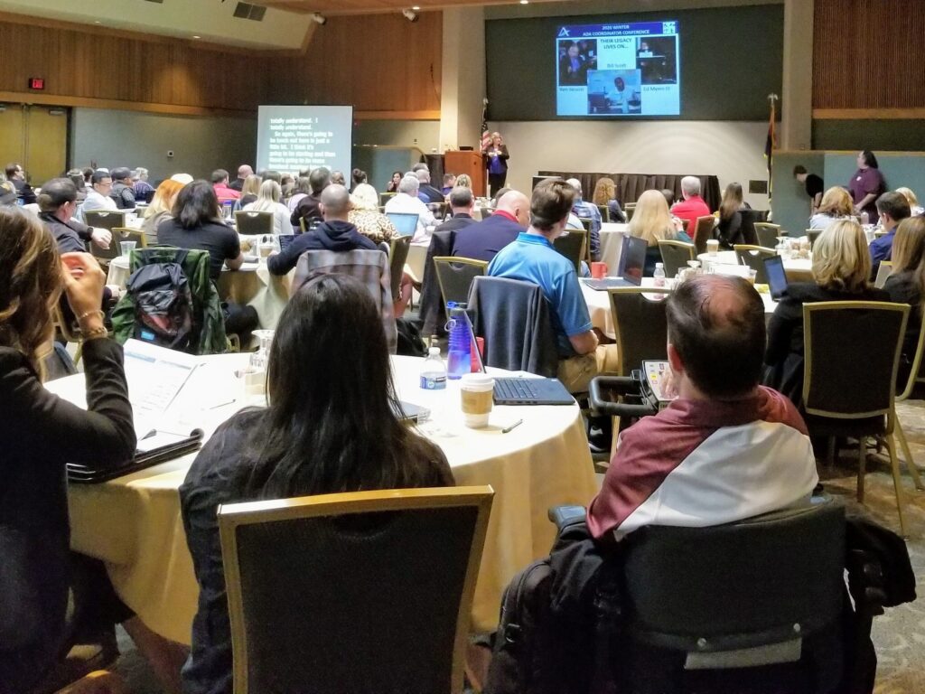 Dr. Nanette Odell speaking in front of a large group at the 2020 Winter ADA Coordinator Conference.