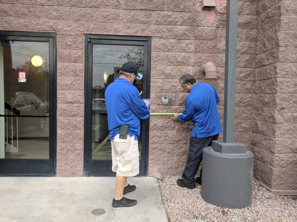 Two Life Quest team members measuring entrance maneuvering clearance.